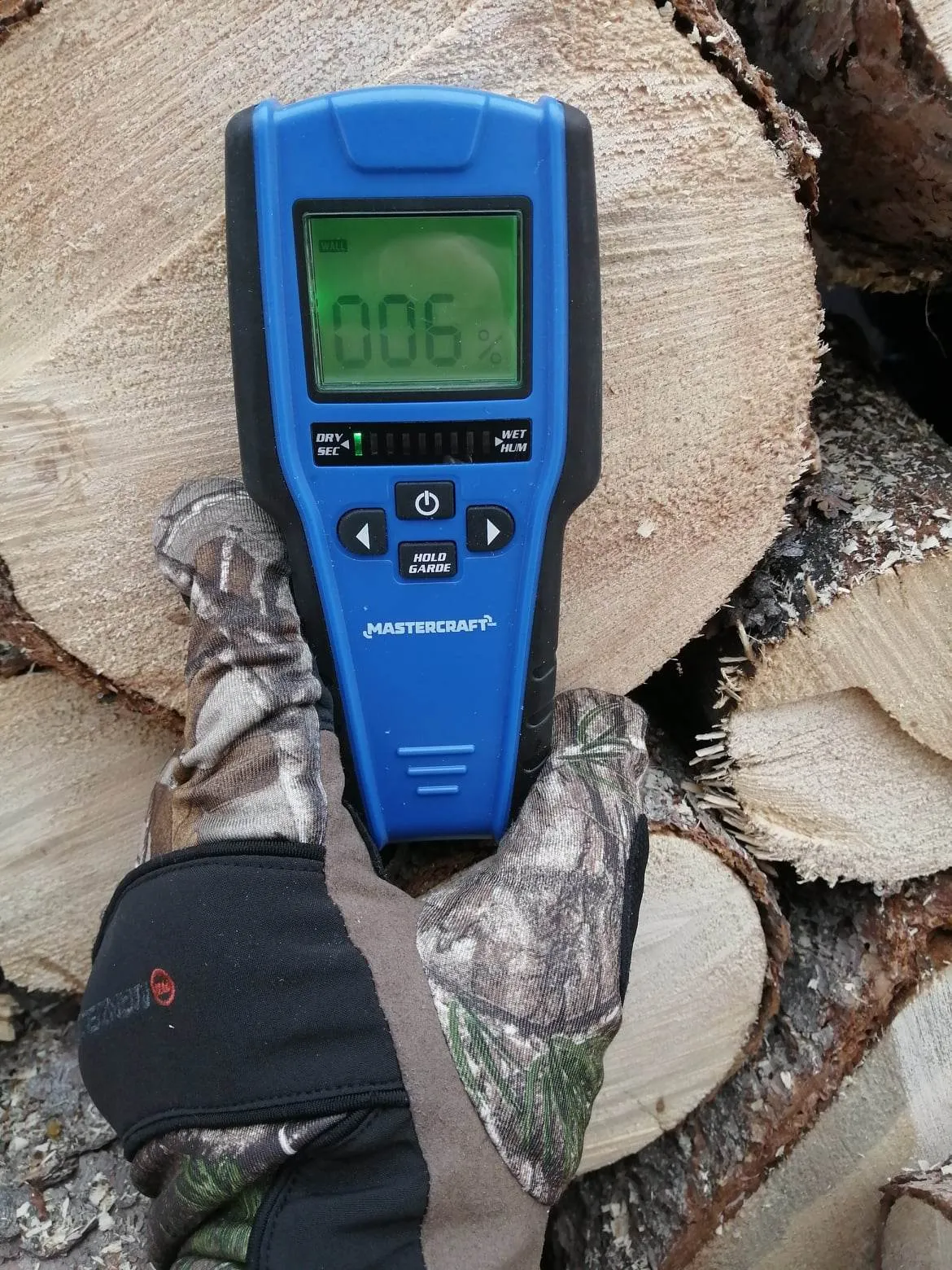 Moisture meter checking a split piece of firewood